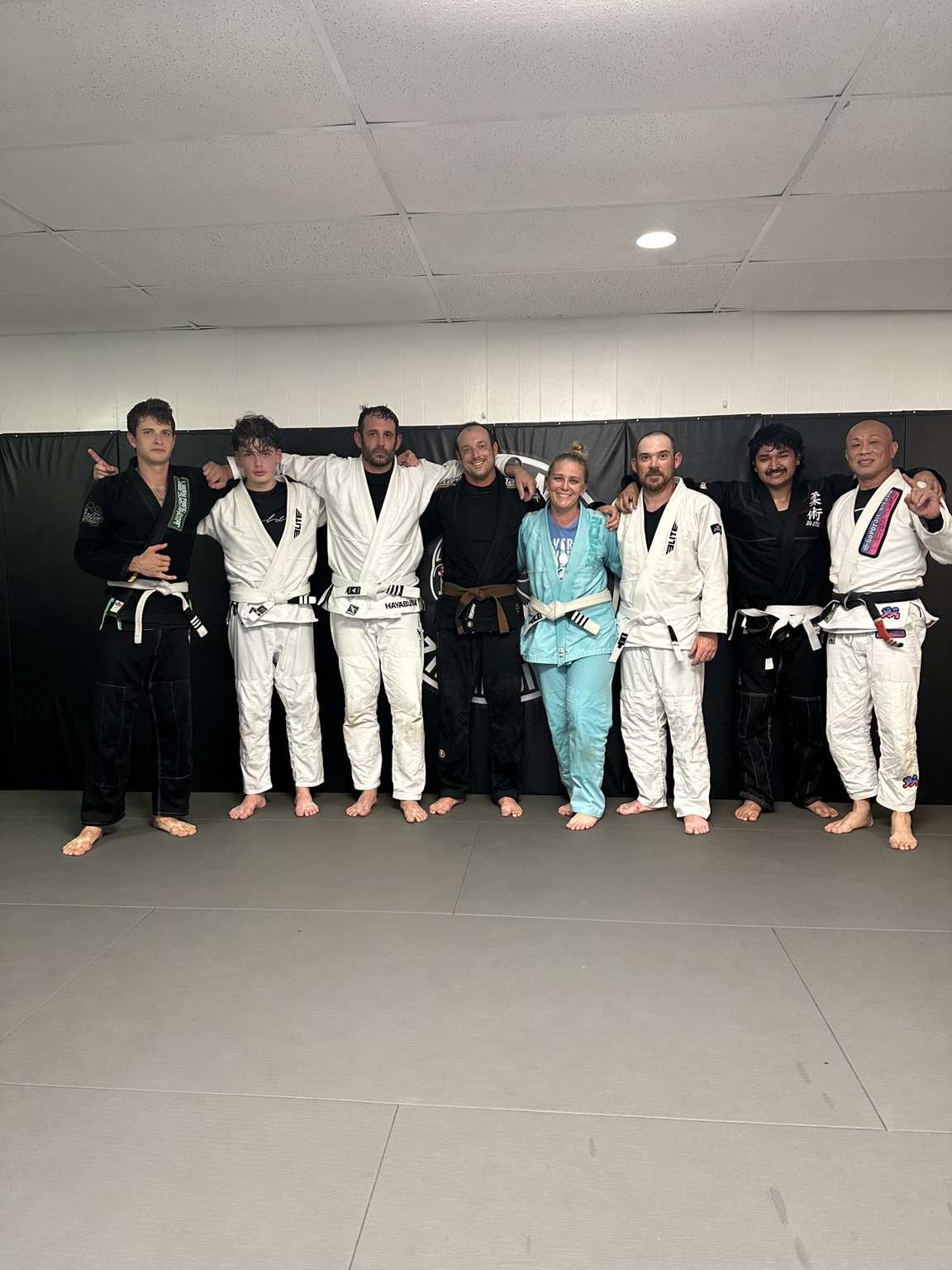 Academy members in gis standing together on the mat